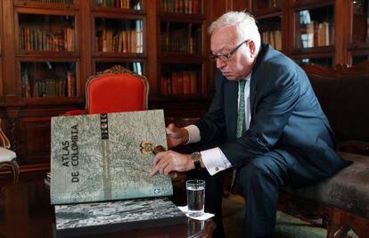 El ministro de Exteriores, Jos&eacute; Manuel Garc&iacute;a-Margallo, observa un atlas durante su visita, este viernes, a la Canciller&iacute;a de Bogot&aacute;.