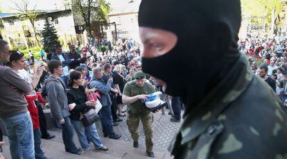 Activistas prorrusos guardan la entrada de la televisión regional en Donetsk.