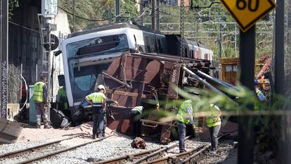 Técnicos y operarios faenan en el lugar donde este lunes se produjo un accidente ferroviario con un muerto y 86 heridos.