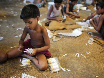 Niños bangladesíes rellenan cigarrillos en una fábrica de Haragach.