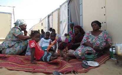 Ndeye Seinabou Fall, a la derecha, se sienta junto a sus hermanas y parte de su familia a tomar café a la sombra de sus nuevas casas en Diougop.