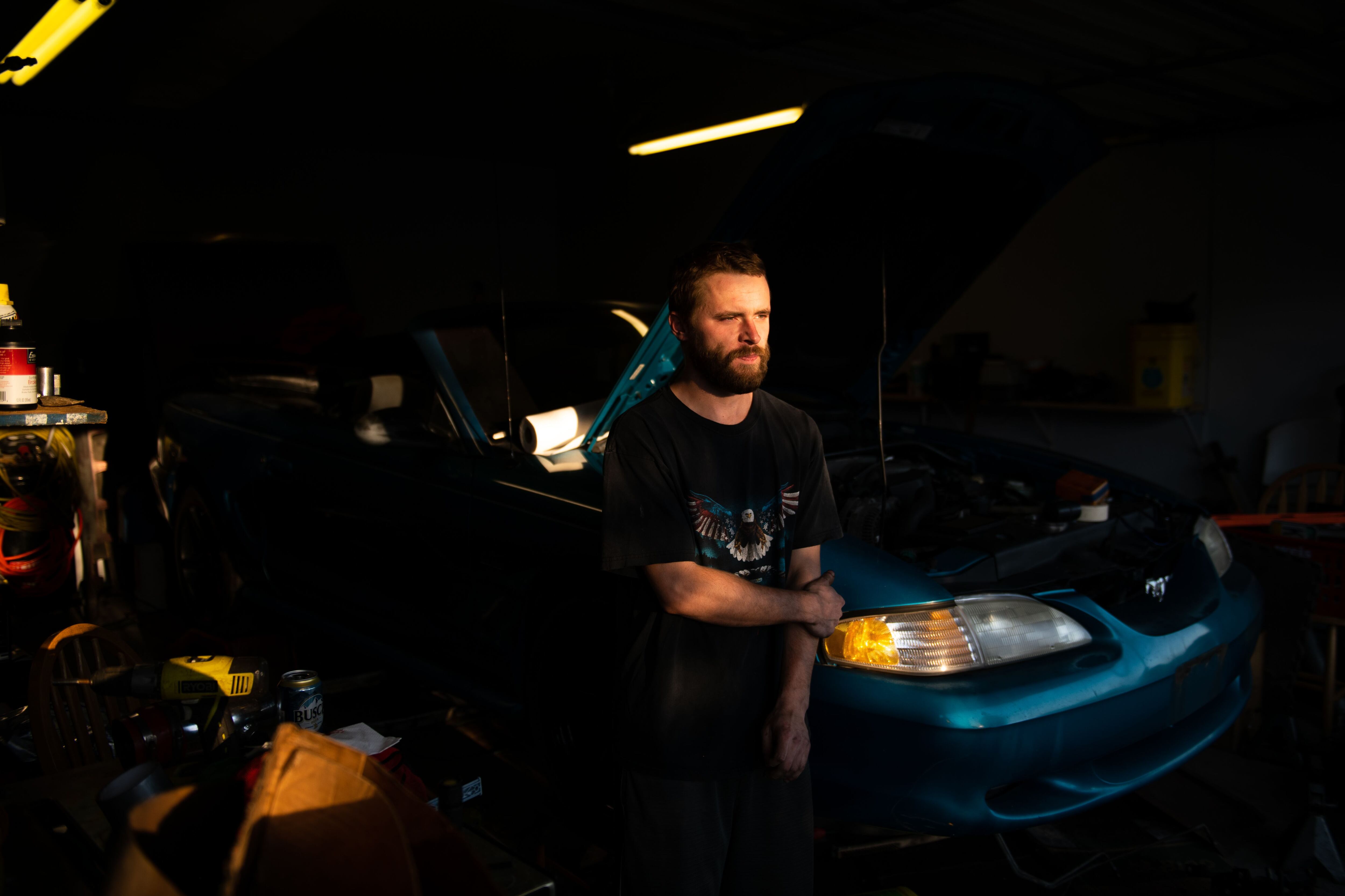 Tyler Wilder se encuentra junto al Ford Mustang '94 que está restaurando en su garaje en Northampton, Pensilvania.