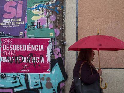 Una mujer pasa ante un cartel del publicidad del referéndum del 1 de octubre en una calle de Barcelona.