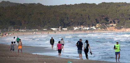 Gente paseando por la orilla de la Playa Llarga (Playa Larga) en Tarragona.