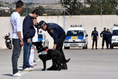 Un perro especialista de la unidad canina de Alicante junto a su agente guía.