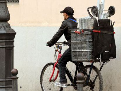 Un recogedor de chatarra circula en su bicicleta por el centro de Valencia.