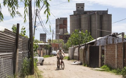 Un hombre circula en bicicleta por una calle de Villa Inflamable.