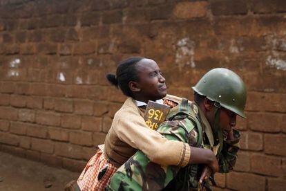 Un policía carga con una niña después de que se viera afectada por gases lacrimógenos mientras dispersan a simpatizantes de la principal coalición opositora este lunes en Nairobi.
