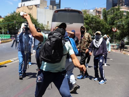 Un manifestante lanza un objeto a la policía durante una marcha por el caso Ayotzinapa frente a las instalaciones de la Fiscalía General de la República (FGR), este jueves en Ciudad de México.