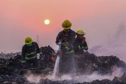 Los bomberos combaten un gran incendio en un vertedero masivo de basura en Yangon, Myanmar.