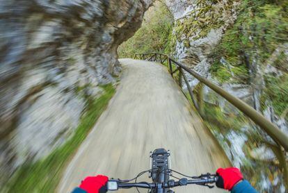 Un ciclista pedalea por un camino en plena naturaleza en Asturias.