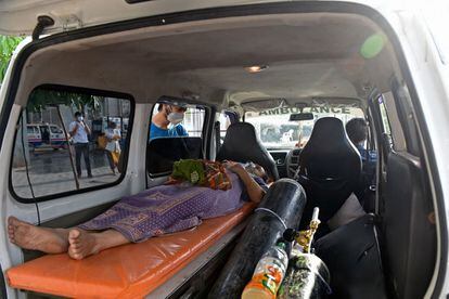En la última jornada, 24 personas han fallecido en un hospital público del estado sureño de Karnataka que agotó sus reservas de oxígeno. Buena parte de los enfermos estaban recibiendo atención médica a causa del coronavirus. En la imagen, una enferma de covid tumbada en el interior de una ambulancia mientras espera su ingreso en un hospital de Ahmedabad, este lunes.