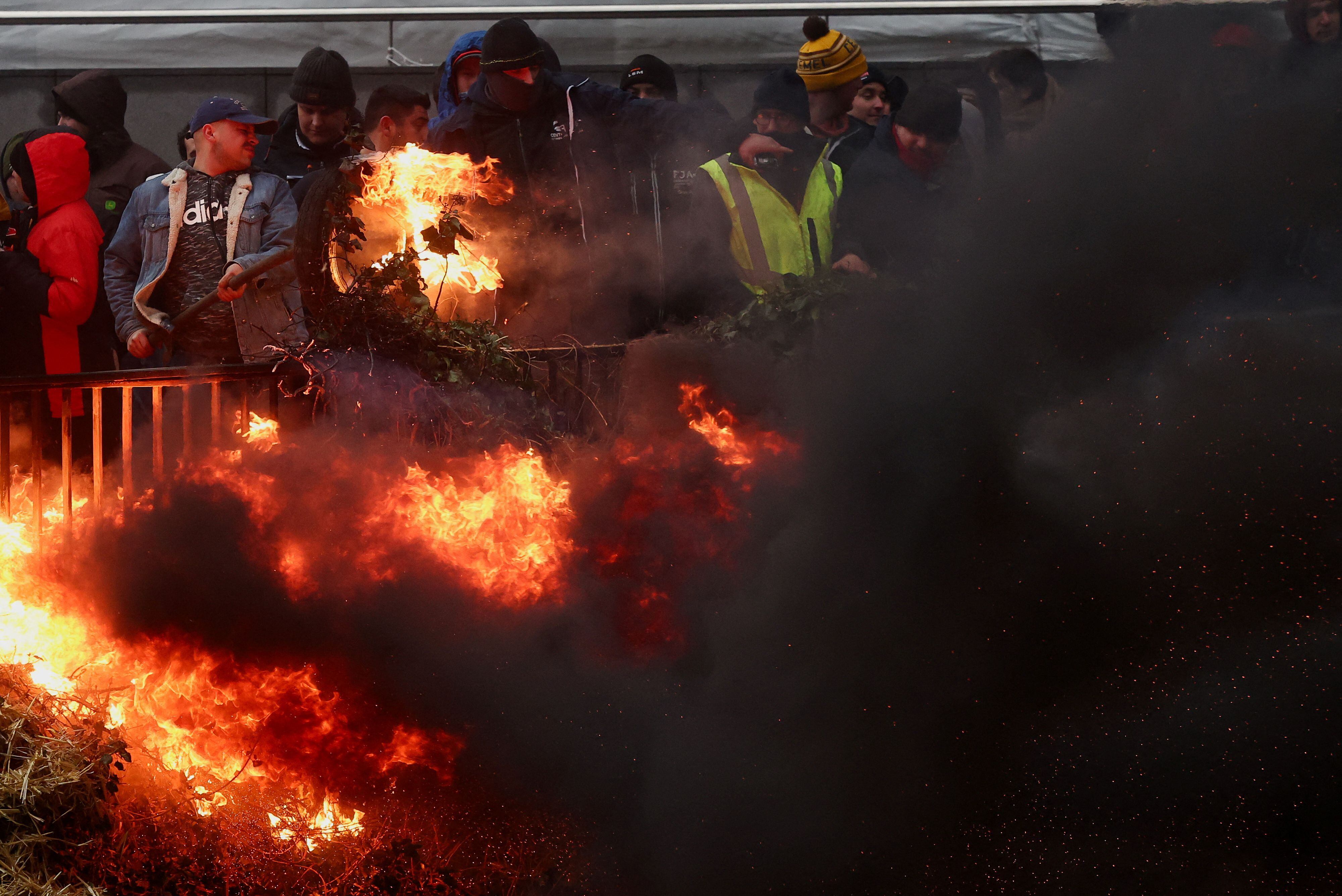 Un grupo de agricultores queman neumáticos durante la protesta ante la sede del Consejo Europeo, este lunes en Bruselas. 