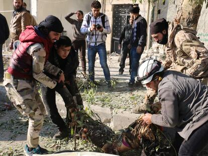 Rebeldes sirios transportan a una víctima de un bombardeo de las fuerzas del régimen de El Asad, este lunes en Alepo.