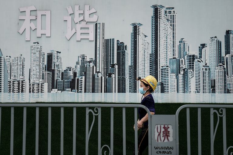 Unos trabajadores caminan frente a una construcción el 16 de septiembre de 2020 en Wuhan (Hubei).