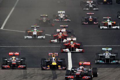 Los McLaren de Button (derecha) y Hamilton (izquierda) lideran la carrera junto al Red Bull de Vettel (centro), en la salida del GP de China.