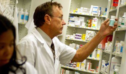 Un farmacéutico busca medicamentos en la rebotica.