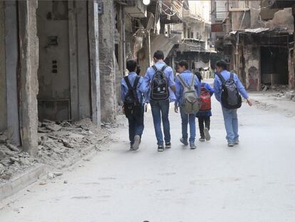 Estudiantes caminan en las calles repletas de escombros del campamento de refugiados de Yarmouk, Damasco, en 2020.