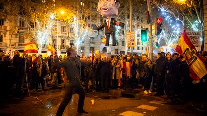 Un hombre se dispone a golpear una piñata que representa a Pedro Sánchez, cerca de la sede del PSOE en Madrid, esta Nochevieja.