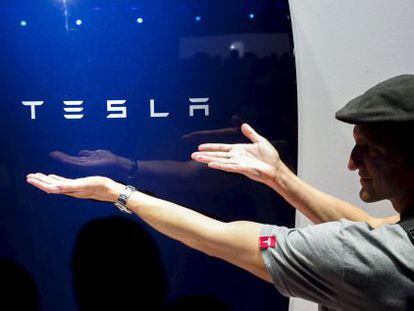 Un hombre muestra una de las superbater&iacute;as de Tesla.