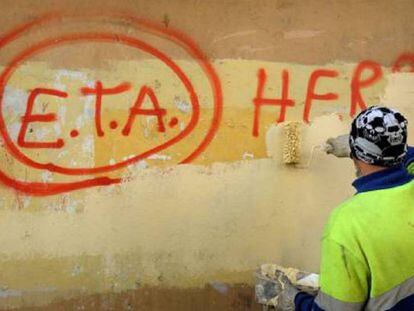 Un trabajador tapa una pintada a favor de ETA en 2011 en Gernika.