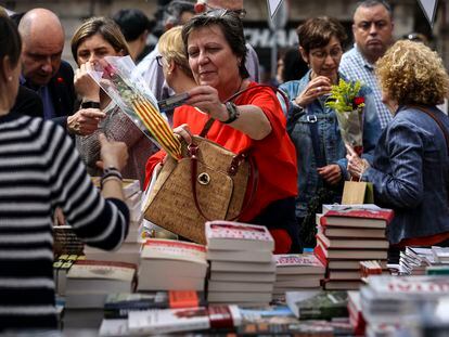Una mujer paga con tarjeta de crédito su compra en una parada de libros en La Rambla de Barcelona durante Sant Jordi.