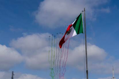 Aviones de la fuerza aérea mexicana sobrevuelan el Zócalo mientras la bandera nacional ondea en el asta de la plaza.