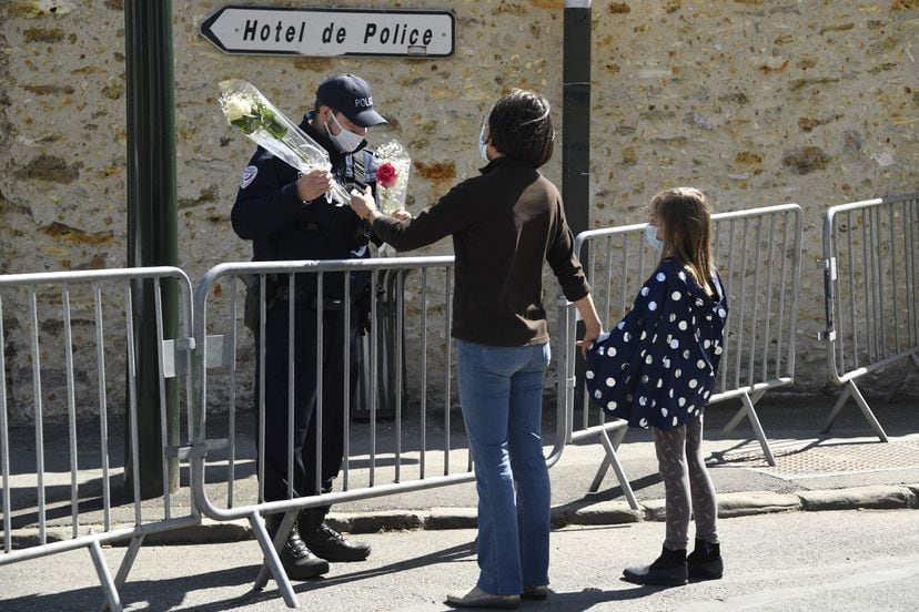 Una mujer entrega un ramo de flores a una policía junto a la comisaría de Rambouillet (cerca de París) donde fue asesinada una agente el pasado viernes.
