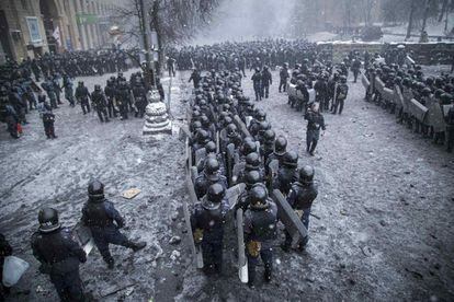 Formación de policías antidisturbios bajo la nieve en la zona del centro de Kiev, donde se están produciendo los enfrentamientos 