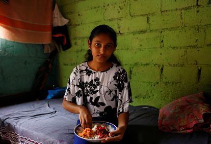 Dilhani Wathsala tiene 14 años y es hija de Nilanthi Gunasekera, de 49 años. Wathsala posa mientras come su almuerzo cocinado por su madre en su casa de Wanathamulla, un barrio del distrito de Colombo, en Sri Lanka, este 7 de agosto. "Antes de la crisis económica, comíamos bien y servíamos carne o pescado a nuestros hijos al menos tres o cuatro veces por semana. Ahora el pescado y la carne están fuera de nuestro alcance", se lamenta Gunasekera.
