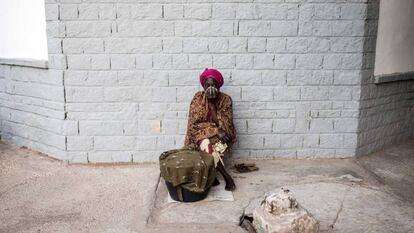 Una mujer senegalesa se cubre la nariz y la boca mientras los trabajadores municipales de Dakar desinfectan una clínica como medida preventiva contra la propagación del coronavirus.