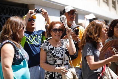 Varias personas se abanican en la calle Alcalá, cerca de la Puerta del Sol, en Madrid.