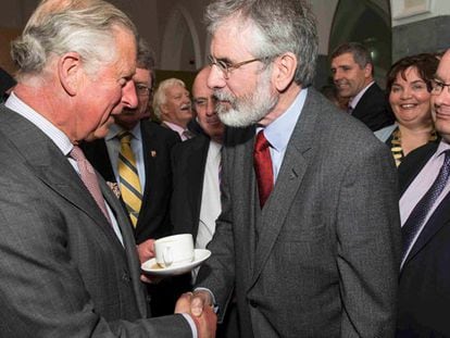 El príncipe Carlos de Inglaterra estrecha la mano al líder del Sinn Féin Gerry Adams, este martes en Londres.