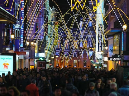 Ríos de gente bajo las luces de Navidad en calle Preciados.