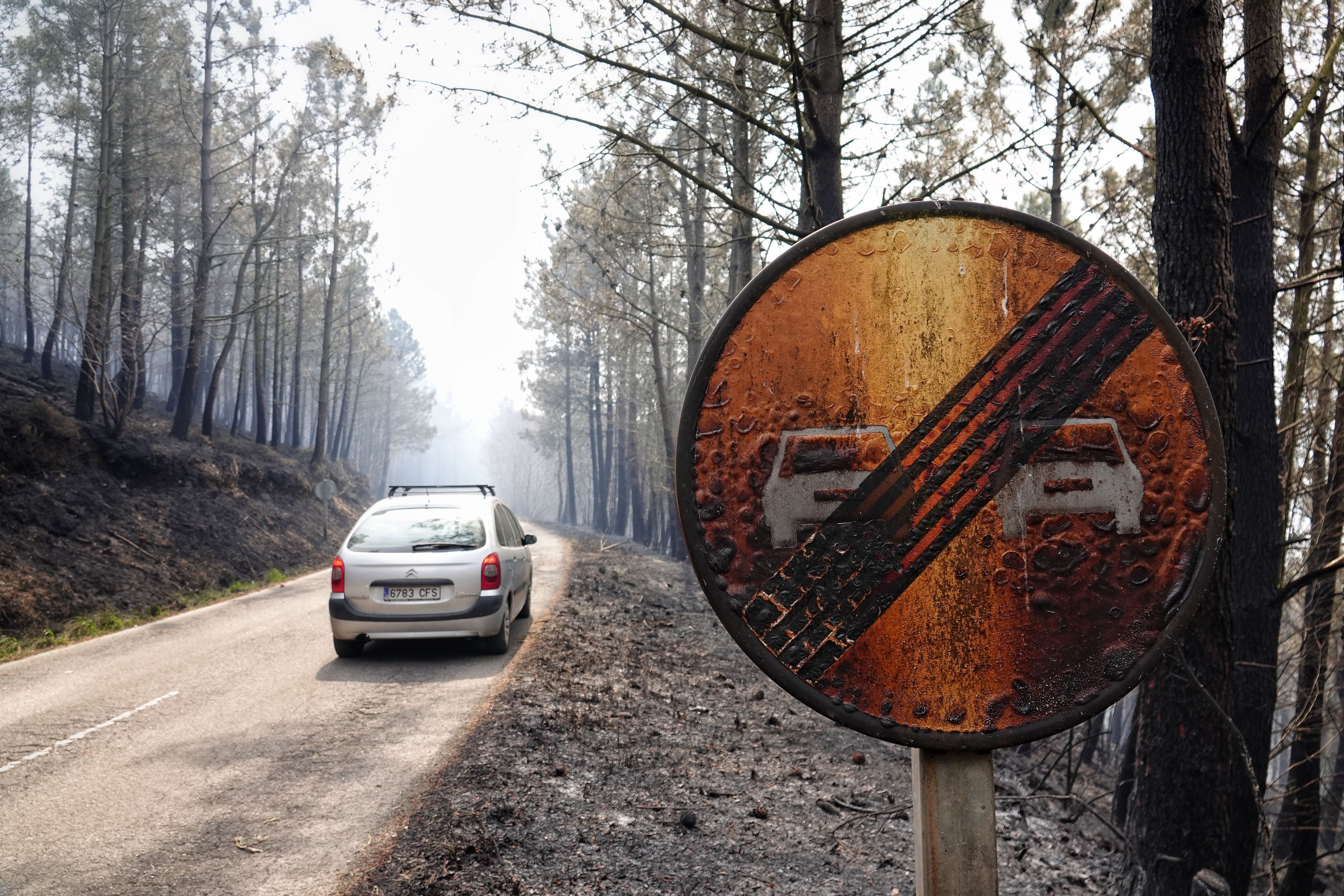 Una señal de tráfico, quemada por el incendio que afecta a los concejos asturianos de Valdés y Tineo, el jueves.