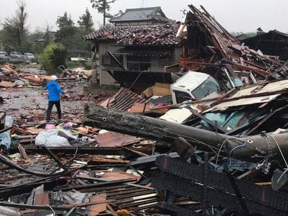 Un hombre camina por los escombros de varias casas desplomadas por el tifón Hagibis en Ichihara, al este de Tokio.