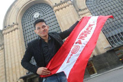 Anthony Escalante posa con la bandera de Perú frente al edificio del Abasto.