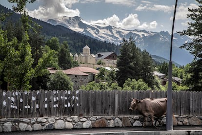 Vista de la cordillera desde la calle principal de Mestia (Georgia), con la iglesia de San Nicolás de frente y sobre el río Mulkhra.