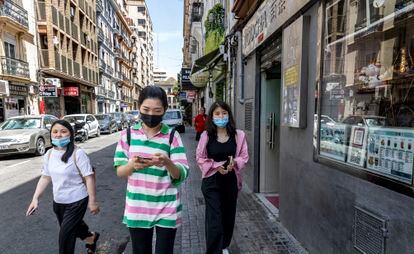 Transeúntes en la calle de Pelayo de Valencia, donde se han establecido numerosos comercios asiáticos. La instalación de unos arcos chinos en su entrada ha dividido a sus vecinos.