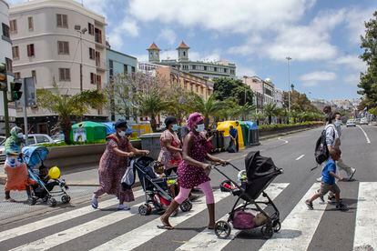 Varias de las usuarias del centro en García Tello cruzan la calle en el paseo diario que realizan con sus hijos, acompañadas por integradoras de la Cruz Blanca.