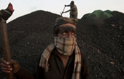 Un joven se toma un descanso mientras trabaja en un depósito de carbón en la ciudad de Karachi (Pakistán).