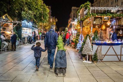 Un hombre con su hijo en el Mercado de Navidad de Santa Lucía en Barcelona.