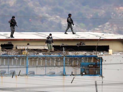 El cuerpo de un preso aparece rodeado por policías en el techo de la penitenciaría Litoral la mañana después de que estallaran los disturbios dentro de la cárcel en Guayaquil, Ecuador, el sábado 13 de noviembre de 2021.