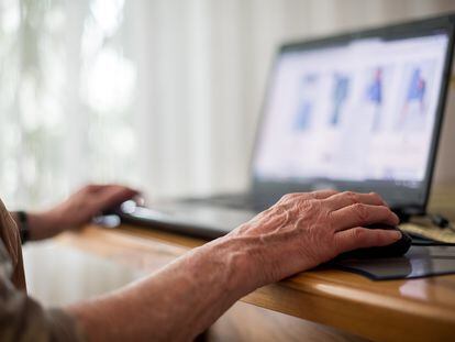 Una mujer mayor usa un portátil.