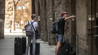 Turistas con sus maletas en una calle del barrio Gótico de Barcelona.