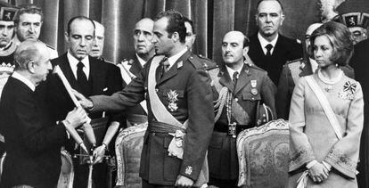 Don Juan Carlos jura la Constituci&oacute;n ante el presidente de las Cortes, Alejandro Rodr&iacute;guez de Valc&aacute;rcel, el 22 de noviembre de 1975. 