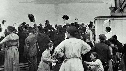 Inmigrantes llegan a Ellis Island a comienzos del siglo XX, con la Estatua de la Libertad al fondo.