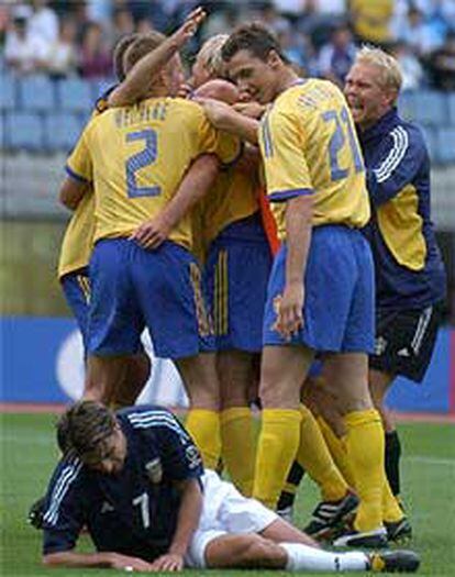 <i>Piojo</i>López llora sobre el césped su desilusión mientras los suecos exhiben su alegría.