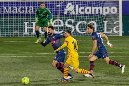 Messi conduce ante la presión de los jugadores del Huesca.