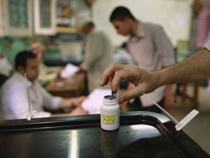 Un egipcio mancha su dedo con la tinta que indica que ya ha votado.